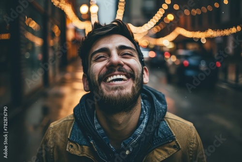 Portrait of a handsome young man laughing in a city street.