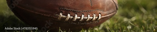 Detailed view of a Gaelic football on the grass, highlighting its stitching and the texture of the leather
