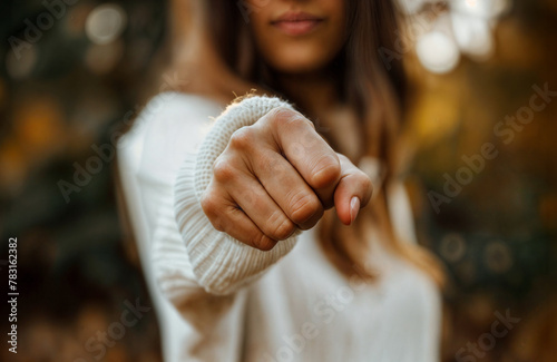 Aggressive woman punching with fist, blurred background 