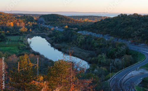 Motorway near Monfalcone, Italy, during an autumn sunset, with the Lokavac canal in the foreground and the Adriatic sea in the background