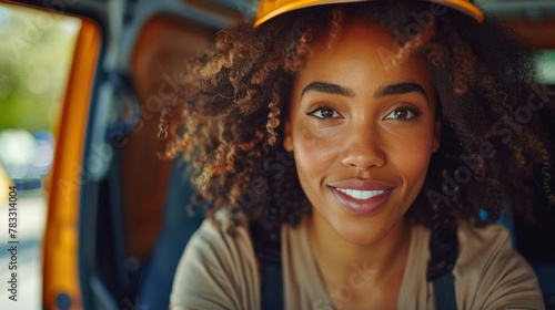 Happy black woman delivery driver driving delivery truck and looking at camera