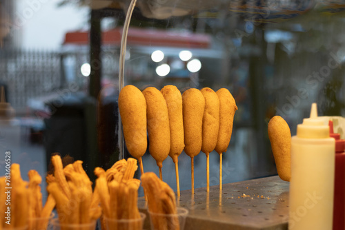 Photograph of a small business that works selling Mexican snacks to its customers on the street of a tourist market where they order churros and traditional banderillas
