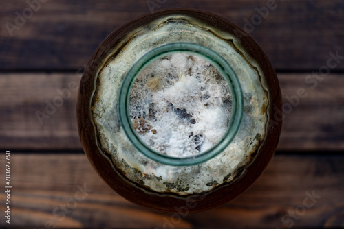 Dangerous mold in a glass jar with sweet drink, closeup, top view. Mold is very dangerous to health. Virus particles, fungus in the drink, old mold in the liquid