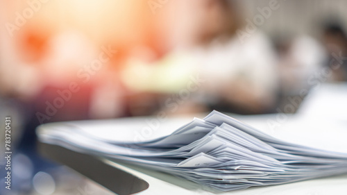 Exam answer sheet pile, blurry application document paperwork stack on office work table in examination room or classroom with blur education background school class university students taking test