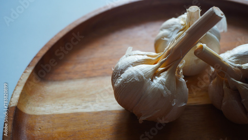 Isolated garlic or Allium sativum on a wooden tray. Selective focus 
