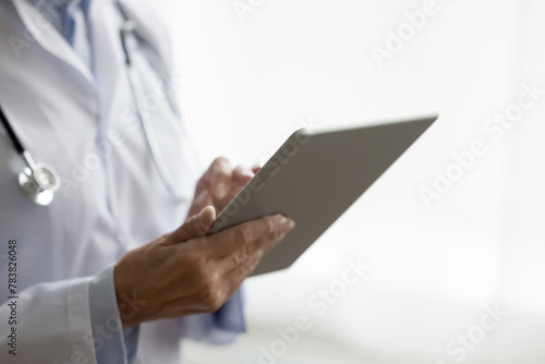 Close up woman therapist using tablet at workplace, lead communication with patient remotely, explain medical conditions, treatment option, and preventive measures. Workflow of GP using modern device