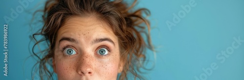 Young woman making a funny surprised face with wide open eyes
