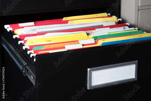 An open black office filing cabinet drawer with blank labels