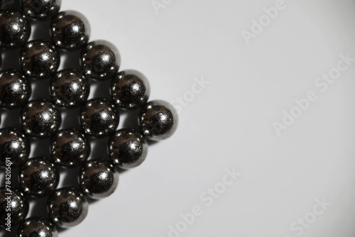 magnetic ball bearing tiling in perfect hexagonal grid. Metal balls close up. Balls of neodymium (magnets).