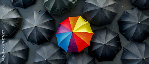Artistic portrayal of a lone rainbow umbrella among numerous black ones