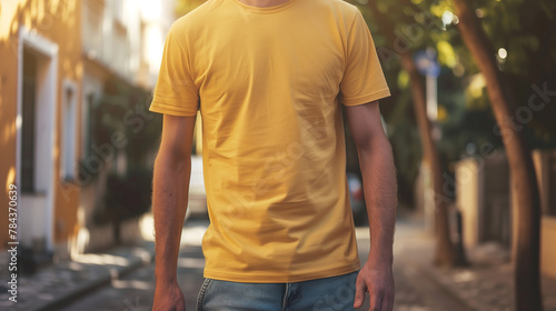Young man wearing plain or empty yellow t-shirt mockup on street for pod product design presentation