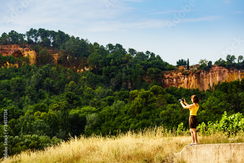 Woman take photo from red rocks in Roussillon, Provence France