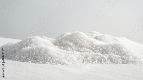 Fine white sand sits in a pile on a plain white surface.