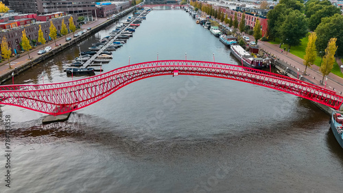 Aerial drone view of modern footbridge Python Bridge at Eastern Docklands neighborhood of Amsterdam Netherlands