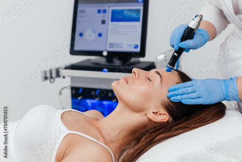 Middle aged woman receiving hydro facial lifting procedure. Natural, mature woman face with healthy freckle skin texture. Aesthetic, facial and skincare cosmetology