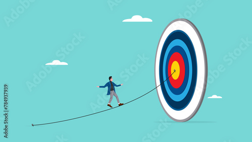 the way to achieve goal with businessman walking through a rope attached to a target board of success, journey or obstacles in achieving business target or goal, success step to achieve business goals