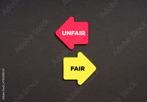 The dilemma between choosing the unfair or fair alternative options. Business concept. The words unfair and fair on arrows pointing opposite directions.