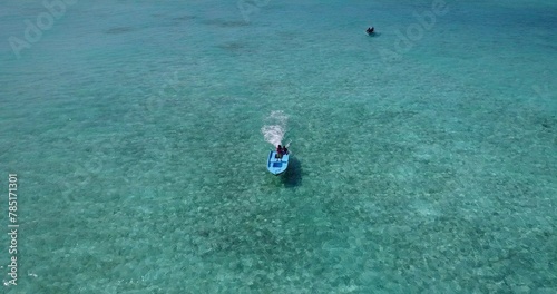 Person riding a small boat in clean waters of the ocean in Asia