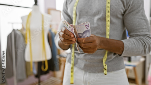 Adult black man counts swedish krona in a tailor shop, indicating profession, finance, and entrepreneurship