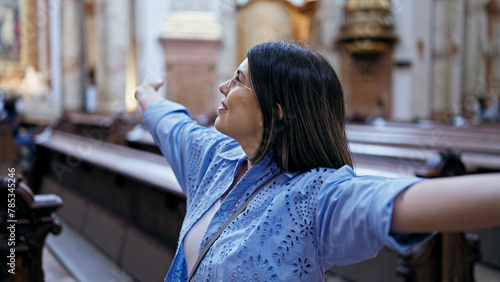 Young beautiful hispanic woman visiting church with open arms at St. Karl BorromÃ¤us church
