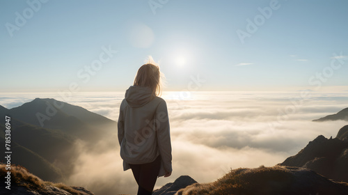 Back view of woman female standing on the cliff, watching sunrise breathtaking and enjoy it.