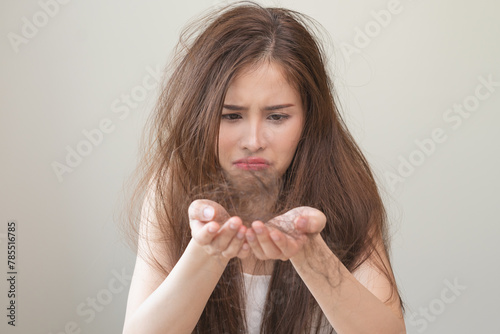 Serious, worried asian young woman, girl holding, show damaged loss hair, problem after brushing, hair fall out on hand. Health care of beauty treatment. Portrait isolated on background, copy space.