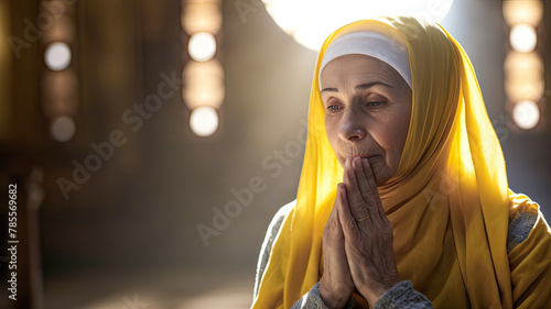 Senior Arab woman, draped in vivid yellow veil, solemnly prays in warmly lit mosque.
