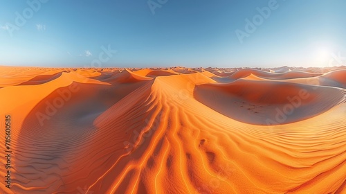  A sizable collection of sand dunes against a backdrop of vibrant blue sky, with the sun prominently positioned at its zenith