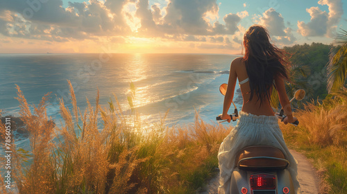 Girl on the island of Bali. The girl on the moped looks at the sunset at the ocean. The sunset sun above the ocean. Traveling to Indonesia Island of Bali.