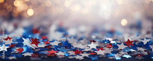 Red, white and blue confetti stars scattered against silver blurred bokeh background. Patriotic banner backdrop for American holidays like July 4th, Memorial, Veteran's, President's Day or elections
