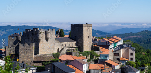 Vista panorámica del castillo de Castrocaldelas en el pueblo de Orense, con tejados y montañas al fondo en un paisaje natural tranquilo, verano de 2021 España