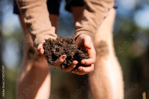 farmer holding soil in hand and pouring soil on ground. connected to the land and environment. soil agronomy in australia. soil heath study