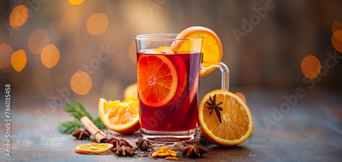 A glass of red drink with orange slices and a cinnamon stick