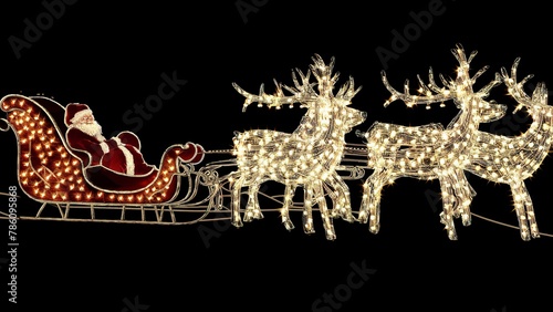 Christmas reindeer from light bulbs with red sleigh of Santa Claus on a black isolated background