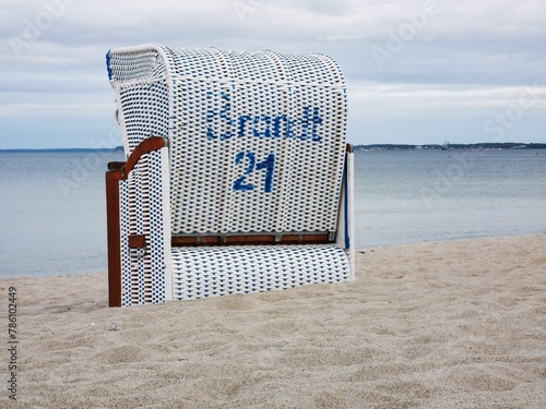 Beach chair on the sand by the sea with the number 21