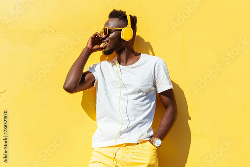 Man in headphones and yellow jeans lissening music