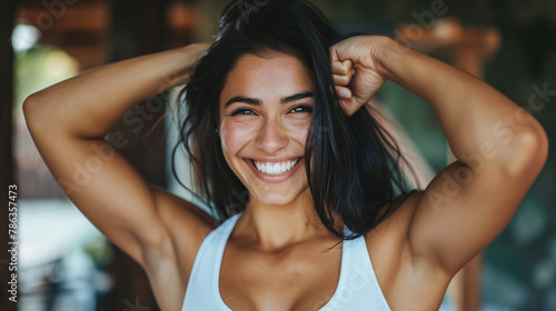 Joyful woman flexing her arm muscles and smiling