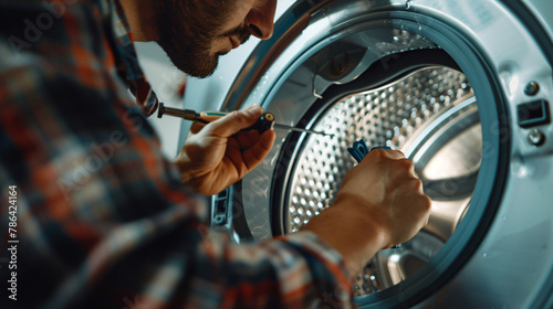 Plumber repairing washing machine with screwdriver 