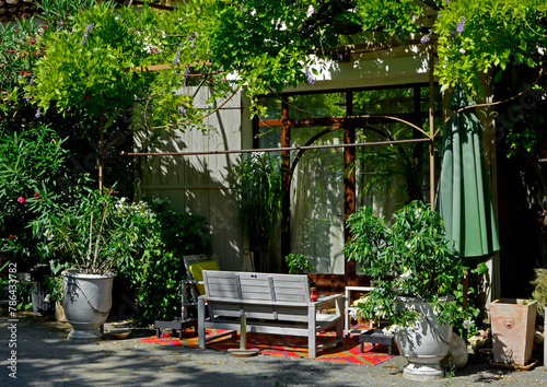 kącik wypoczynkowy na patio przed domem, meble ogrodowe na tarasie przed domem, biała drewniana ławka i donice w kąciku wypoczynkowym, sitting area in the garden, Recreation area 