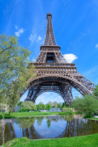 Tour Eiffel près de l'eau et au milieu des arbres sous un ciel bleu à Paris