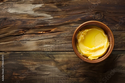 Traditional ghee in a rustic wooden bowl with copy space. Rich and creamy ghee on wooden surface