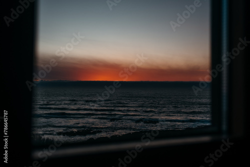 Tranquil seaside sunset view through window in Larino, Galicia