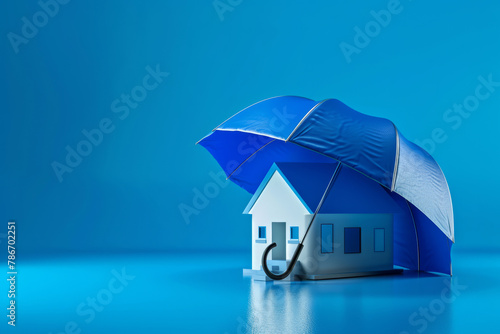 Home insurance or tenants mortgage protection concept, model house under umbrella on blue empty background with space for text or inscriptions 