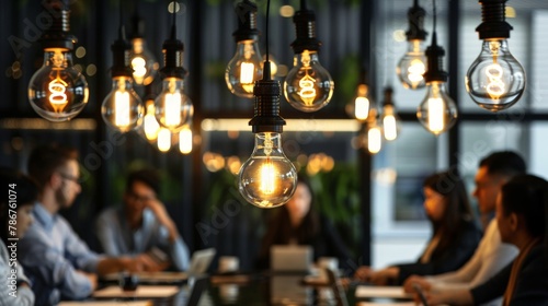A roundtable discussion under a canopy of hanging lightbulbs, with one bulb shining brightest as a team member articulates their idea, highlighting the moment of insight and collective enthusiasm.
