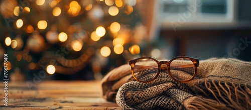 A close-up view of a stylish pair of spectacles and a colorful scarf casually placed on a wooden table