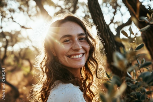 Portrait of a beautiful young woman with freckles on her face in an olive grove