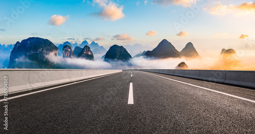 Asphalt highway road and karst mountain with sky clouds at sunrise. Panoramic view.