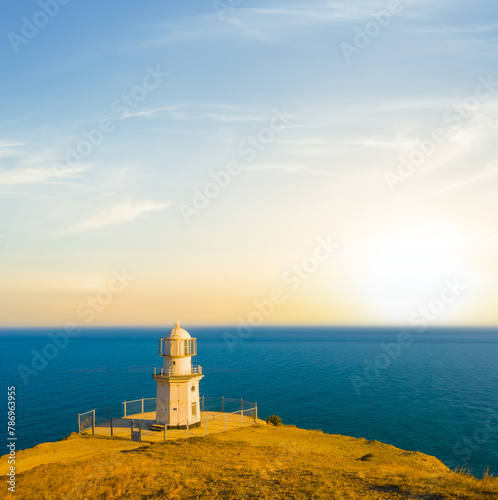 lighthouse on a marine cape at the sunset