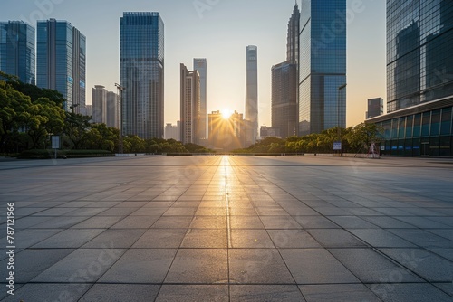 empty square concrete floor of a modern downtown with bright light coming during sunset from the modern huge buildings in the evening