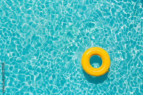 Aerial view of swimming pool transparent turquoise water. Yellow pool float, ring floating.